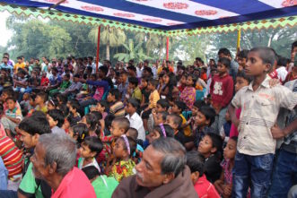 Opens popup gallery with Community members watching a Theater for Development show on gender equality in Rajshahi.