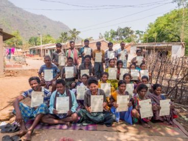 Opens popup gallery with Poduchan villagers display their land right titles 