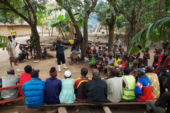 Opens popup gallery with Achmed Sesay, a Namati paralegal, addresses a gathering of villagers in Masethele village, Sierra Leone.