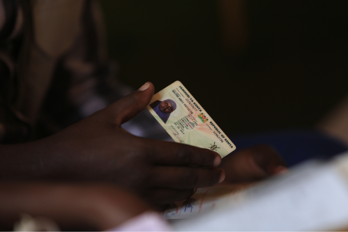 A hand holding a woman's ID card.